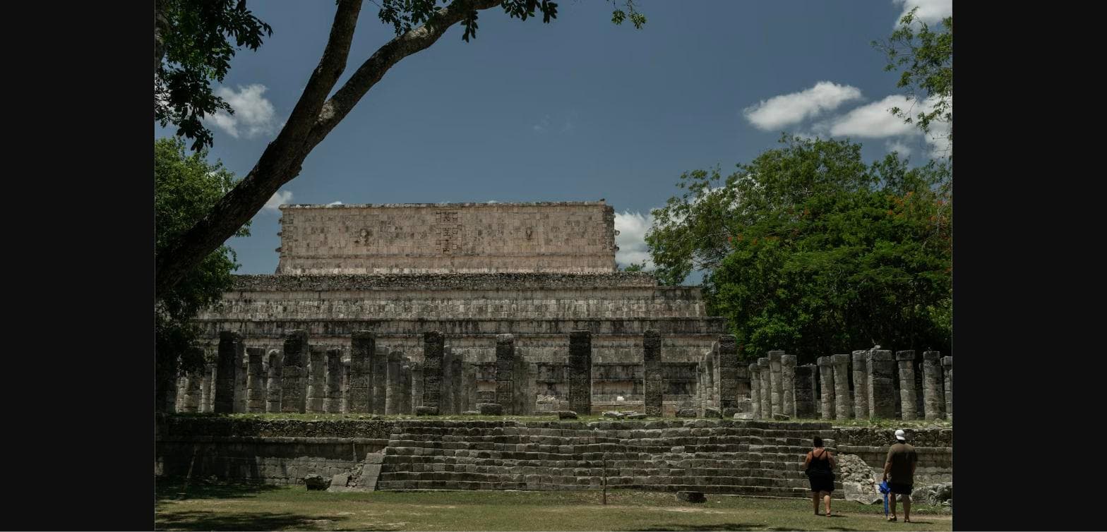El Castillo pyramid and ancient ruins at Chichen Itza in tranquil morning sunlight